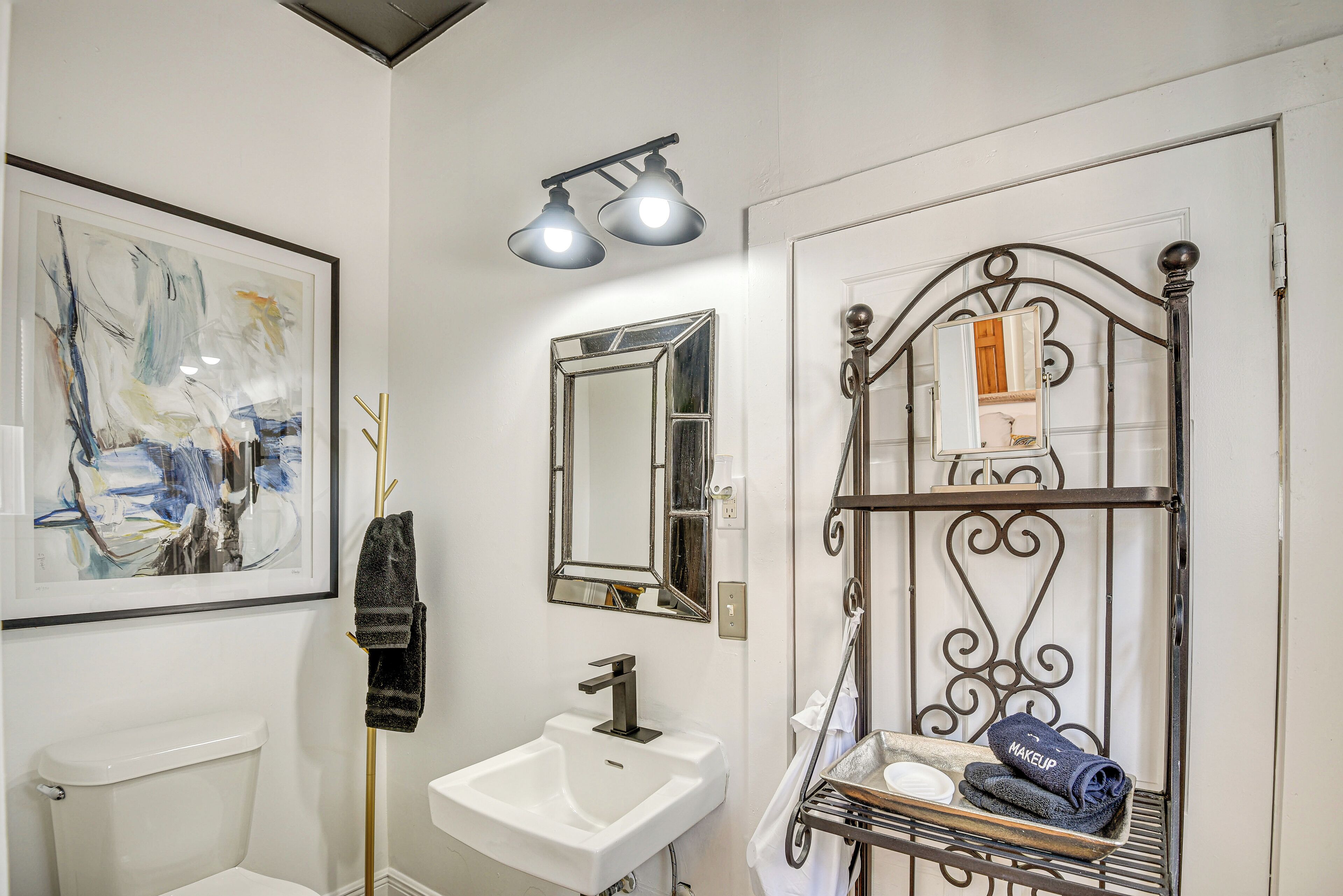 A bathroom with a white sink, a mirror, and a towel rack.