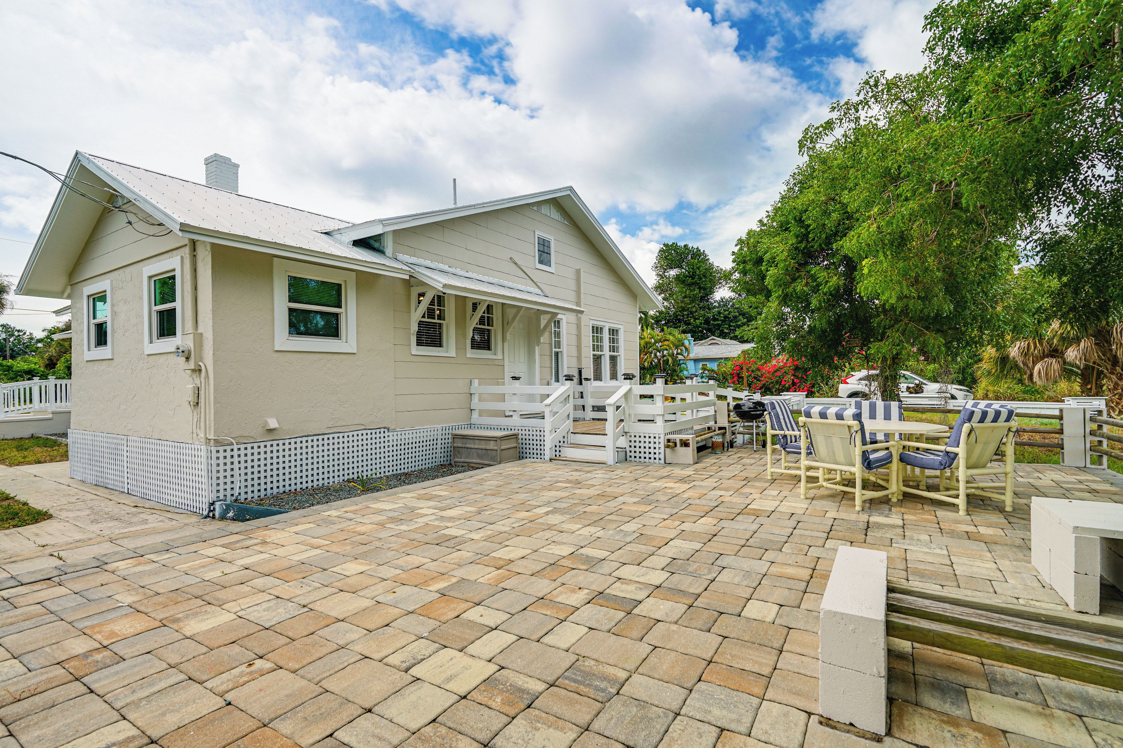Ein Haus mit Terrasse, Gartenmöbeln und einem eingezäunten Deck.