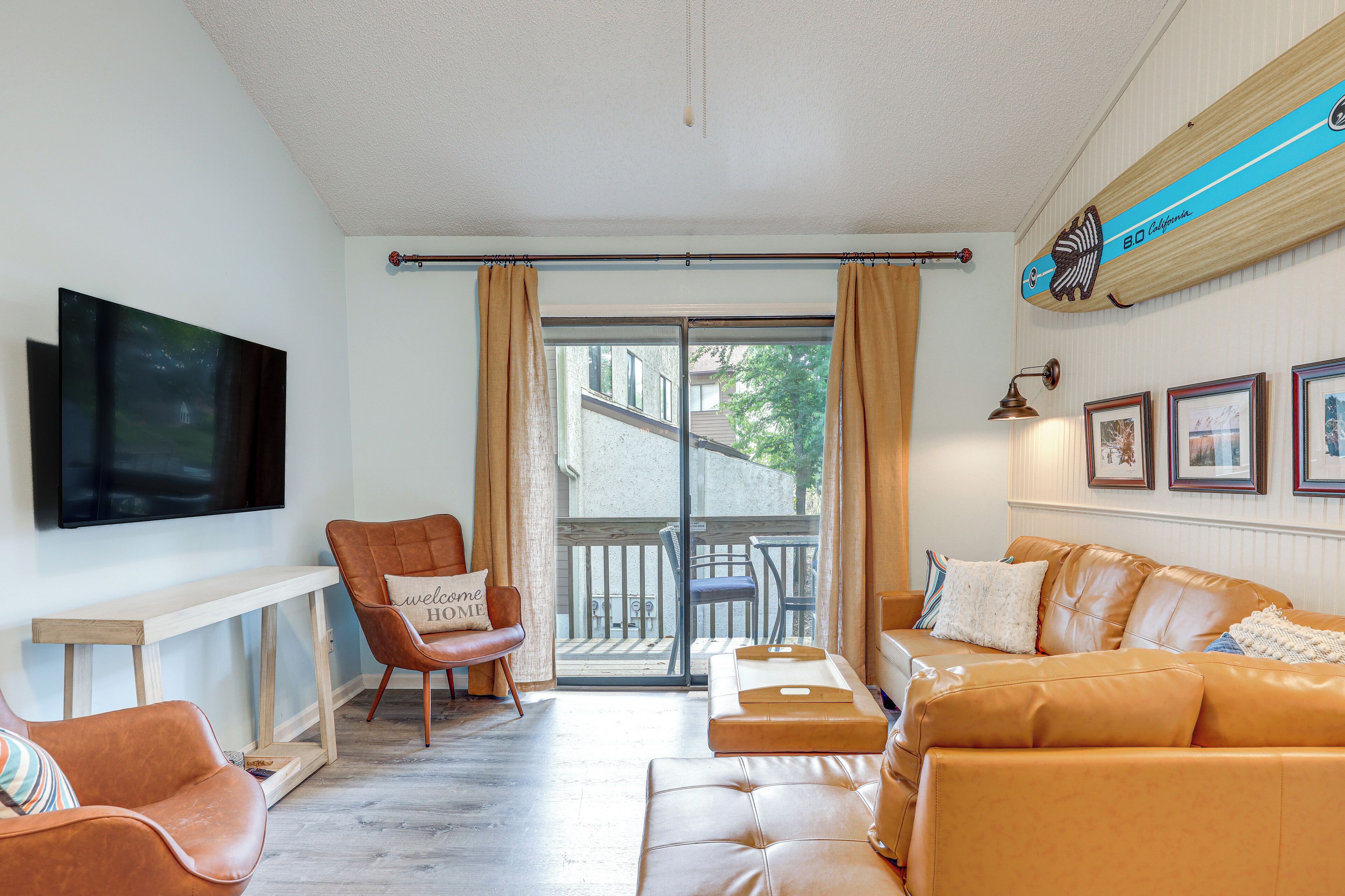 A living room with a sofa, armchair, and a television.