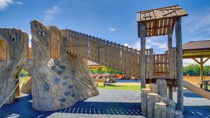 Un parque infantil con estructuras para escalar y un puente de madera.