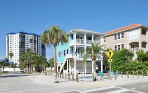 Un hôtel situé en bord de mer, avec une structure à deux étages, un balcon et un panneau de signalisation pour le passage des piétons.