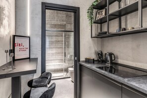 A modern kitchen with a glass door, a framed quote on the wall, and a coffee maker on the counter. - Gallery Home Napoli (Naples)