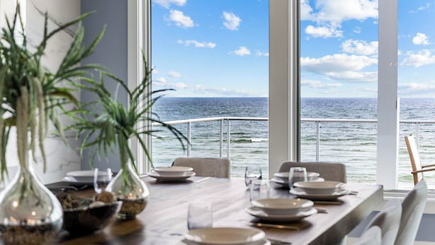 A dining area with a view of the ocean through large windows. - Bluebell: Beachfront, Private Pool, Arcade Games, Plantation (St. George Island)