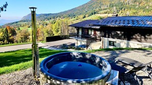 Ein Whirlpool mit Blick auf einen Berg und ein Haus mit blauem Dach.