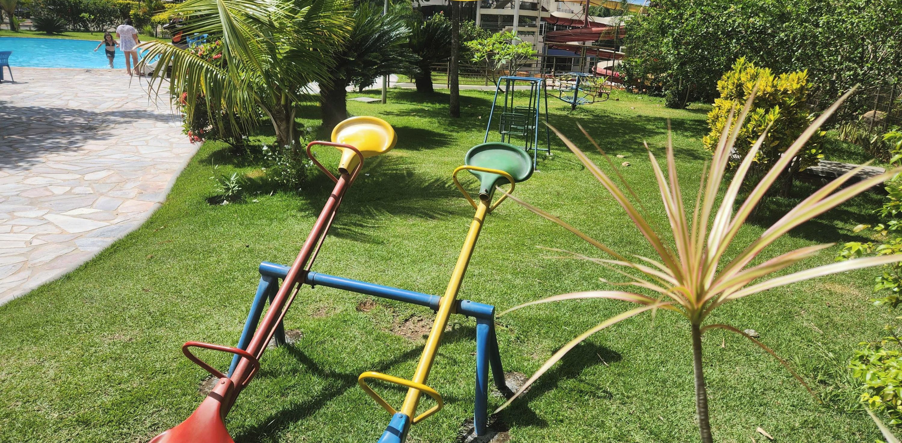 A children's play area with swings and a small garden.