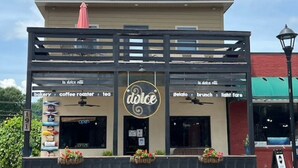 A building with a sign reading "dolce" and various business names like "bakery," "coffee roaster," and "tea."