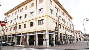 A multi-story building with a ground-level commercial space, a no-entry sign, and a bicycle parked outside. - STUDIO VENICE GUESTHOUSE (Mogliano Veneto)