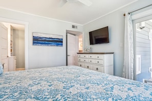 A bedroom with a bed, a dresser, a TV, and a painting on the wall. - New Listing -- 3 BR Oceanfront Condo in Duck with pool (Duck)