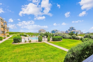 A residential area with a swimming pool, green lawns, and multi-story buildings.