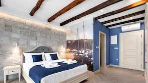 Een slaapkamer met een bed, nachtkastje en een groot muurdecor.