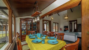 A dining area with a yellow tablecloth, blue plates, and wooden chairs. - The Winterfell (Kotagiri)