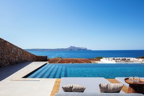 An infinity pool with a clear view of the sea and a mountainous island in the distance. - DioNysos Boutique Villa (Chania)