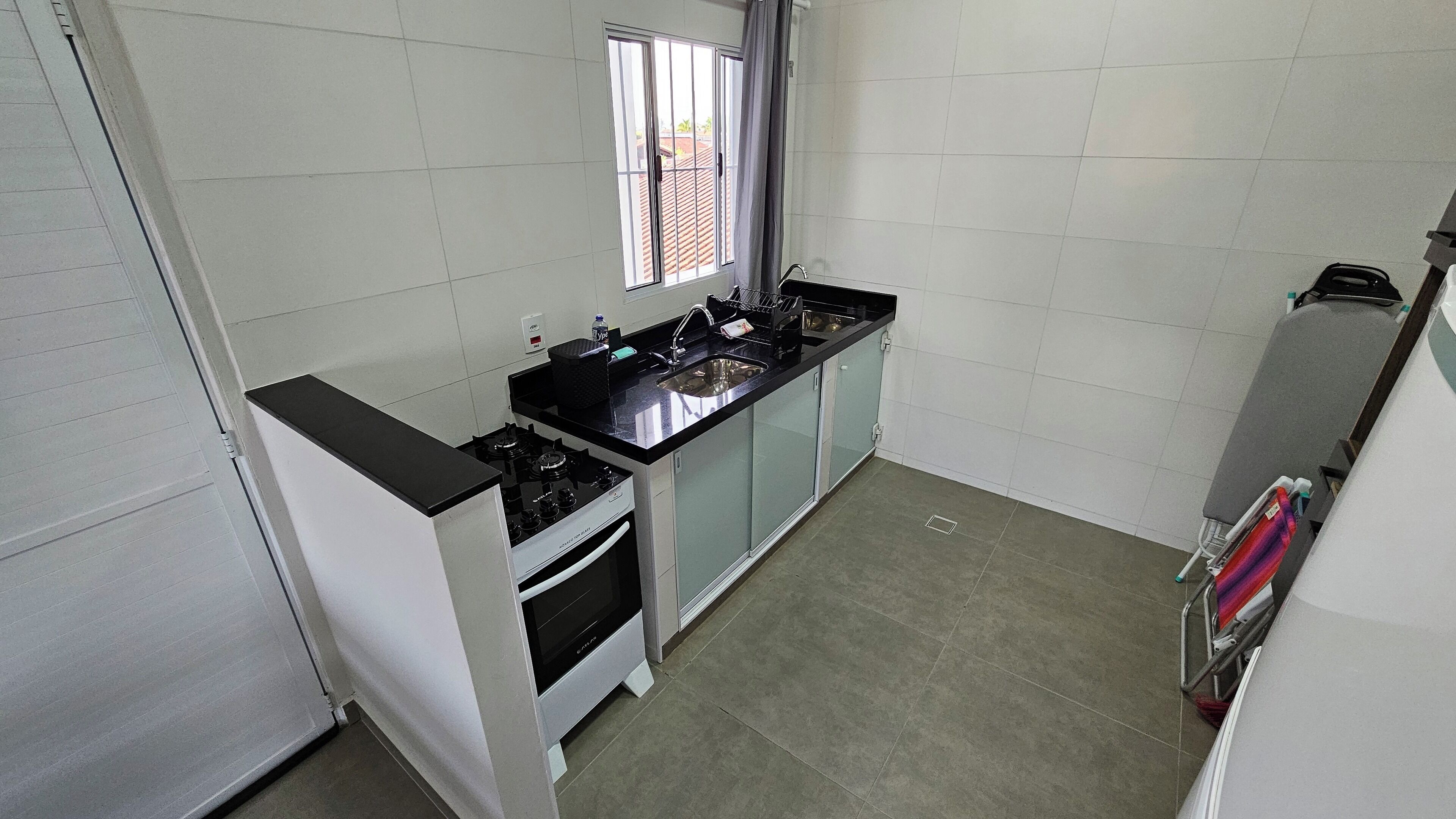 A compact kitchen with a gas stove, a sink, and a window.