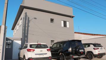 Guests can park their vehicles in front of this building, which features a flat roof and simple design.