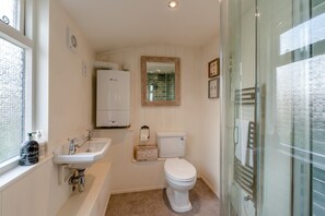 Un baño con lavabo, inodoro y zona de ducha.