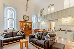 A spacious living area with leather sofas, a wooden coffee table, and a dining area with a table and chairs. - 2 Bed in Goodleigh (oc-l29573) (Goodleigh)