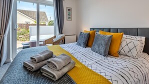 A hotel room with a bed, a view of the outside, and a chair by the window. - 3 Bed in Braunton (oc-b29581) (Braunton)