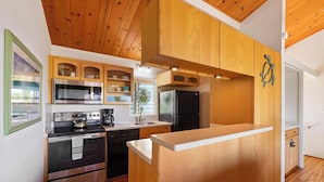 Una cocina moderna con armarios de madera, electrodomésticos de acero inoxidable y encimera de madera.
