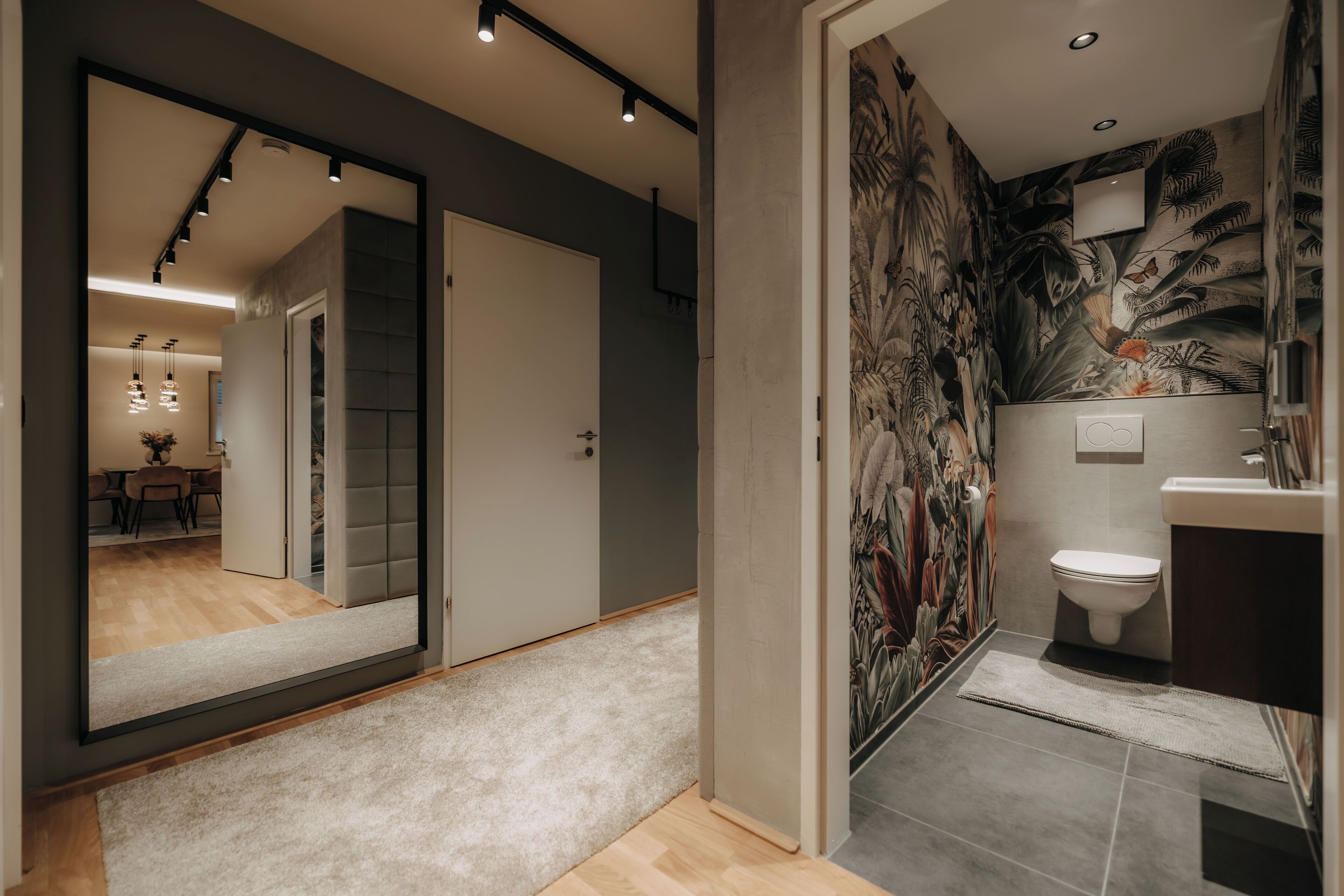 Un bagno moderno con uno specchio grande, un water e una zona doccia.