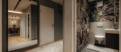 Un bagno moderno con uno specchio grande, un water e una zona doccia.