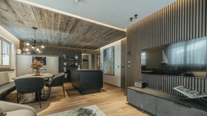 Een moderne woonkamer met een houten plafond, een eethoek en een keuken.