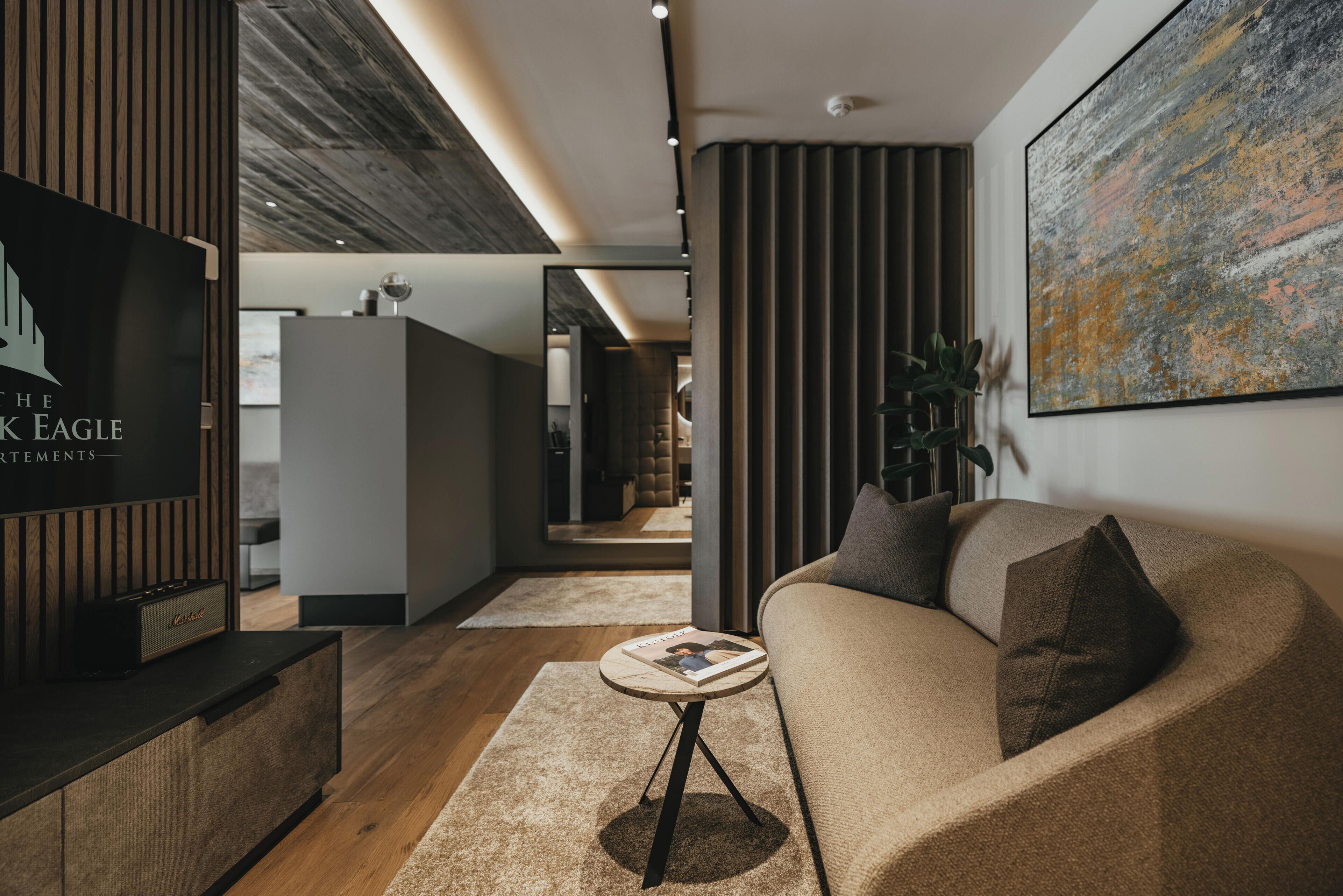 A modern living room with a sofa, a coffee table, and a television.