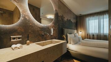 A modern bathroom with a large mirror, a sink, and a shower.