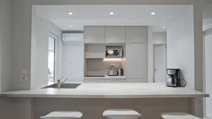 A modern kitchen with a central island, built-in appliances, and a coffee machine.