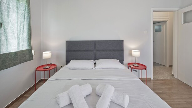 A hotel room with a large bed, two bedside tables, and a view of a hallway. - Alemar Quiet Kallithea Retreat with AC, Wifi (Kalithea)