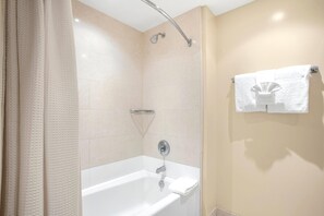 Ein Badezimmer mit Badewanne, Dusche und Handtuchhalter.