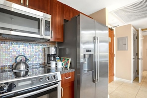 A kitchen with a stainless steel refrigerator, microwave, and stove.