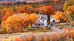 A house surrounded by autumn foliage. - Hancock Historic Bed & Breakfast with Personal Chef Made-to-Order Full Breakfast (Hancock)