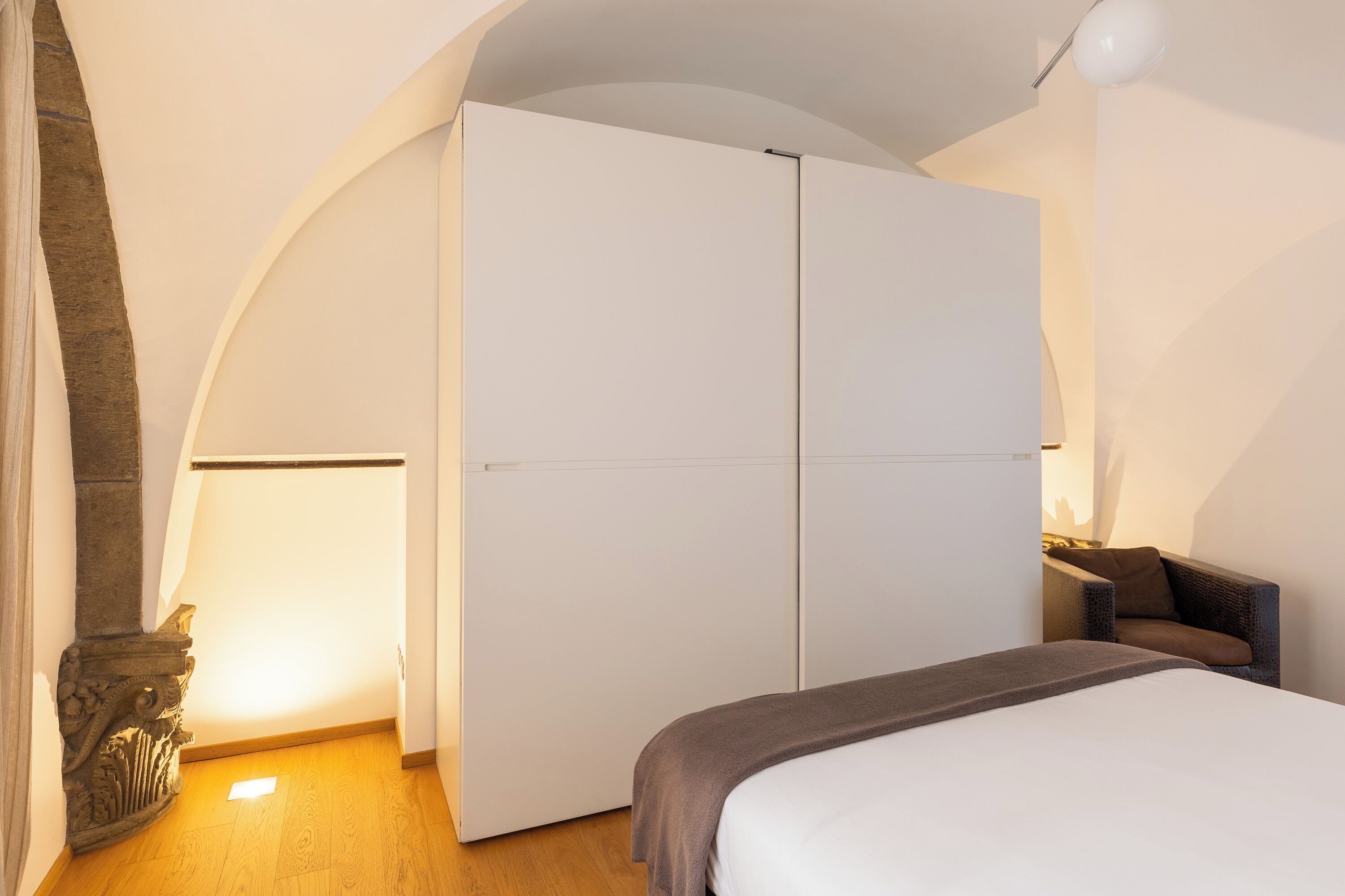 Ein Schlafzimmer mit Bett, Kleiderschrank und Stuhl.
