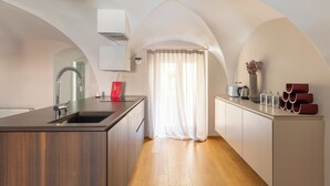 A modern kitchen with a central island, wooden cabinets, and a built-in oven.