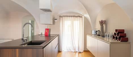 A modern kitchen with a central island, wooden cabinets, and a built-in oven.