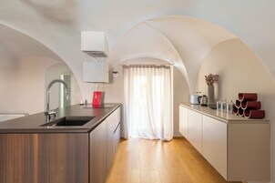 A modern kitchen with a central island, wooden cabinets, and a built-in oven.