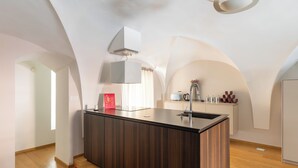 A modern kitchen with a central island, built-in cabinets, and a pendant light.