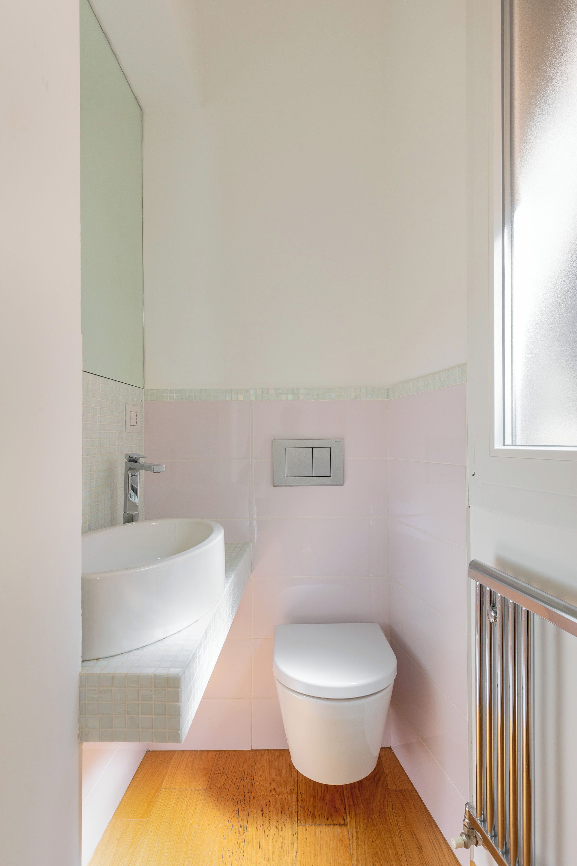 A bathroom with a white bathtub, a white toilet, and a wooden floor.