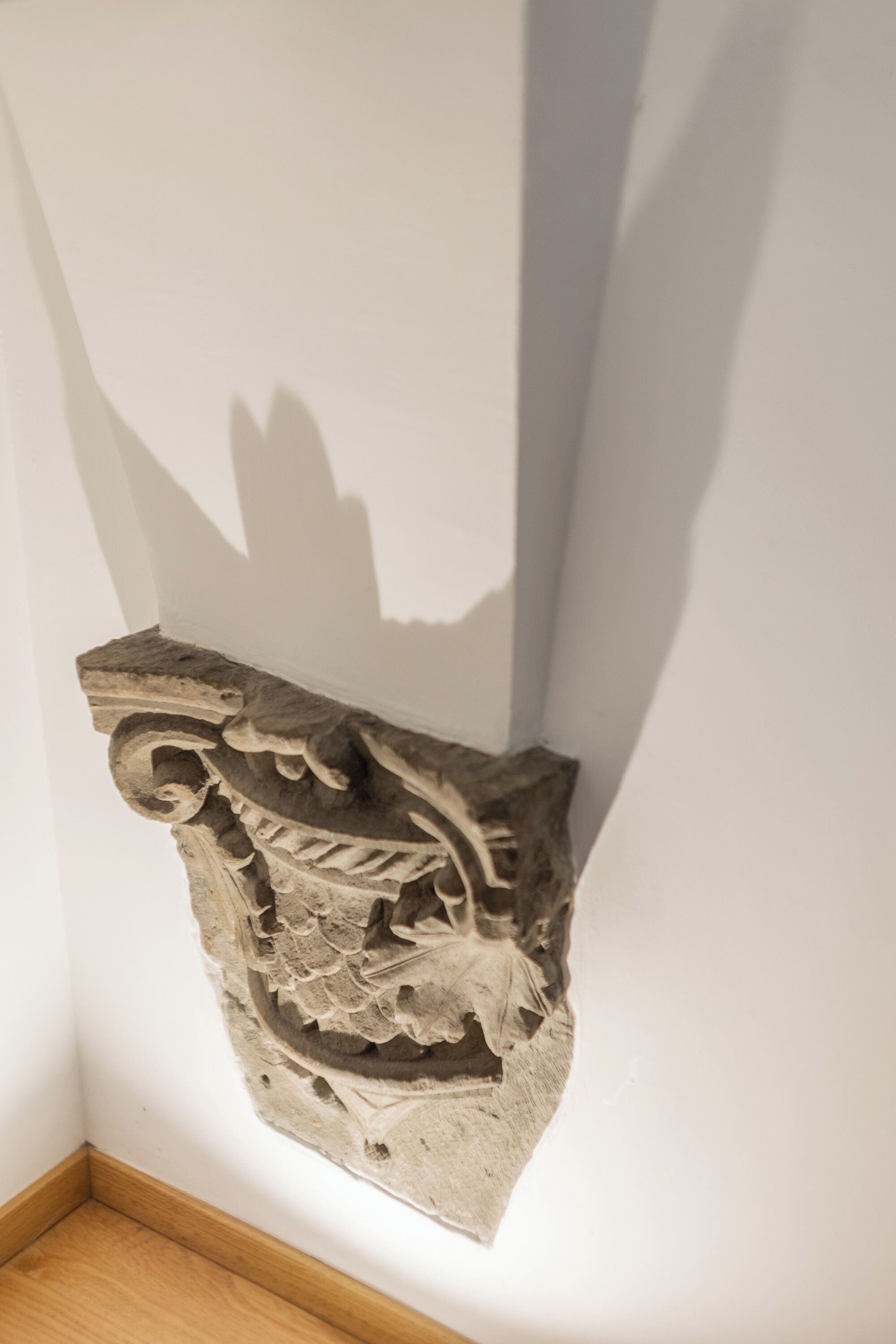 A corner of a room with a decorative stone carving on the wall.