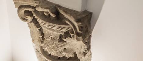 A corner of a room with a decorative stone carving on the wall.