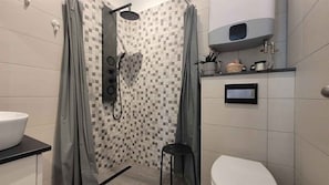 A modern bathroom with a shower, toilet, and sink.