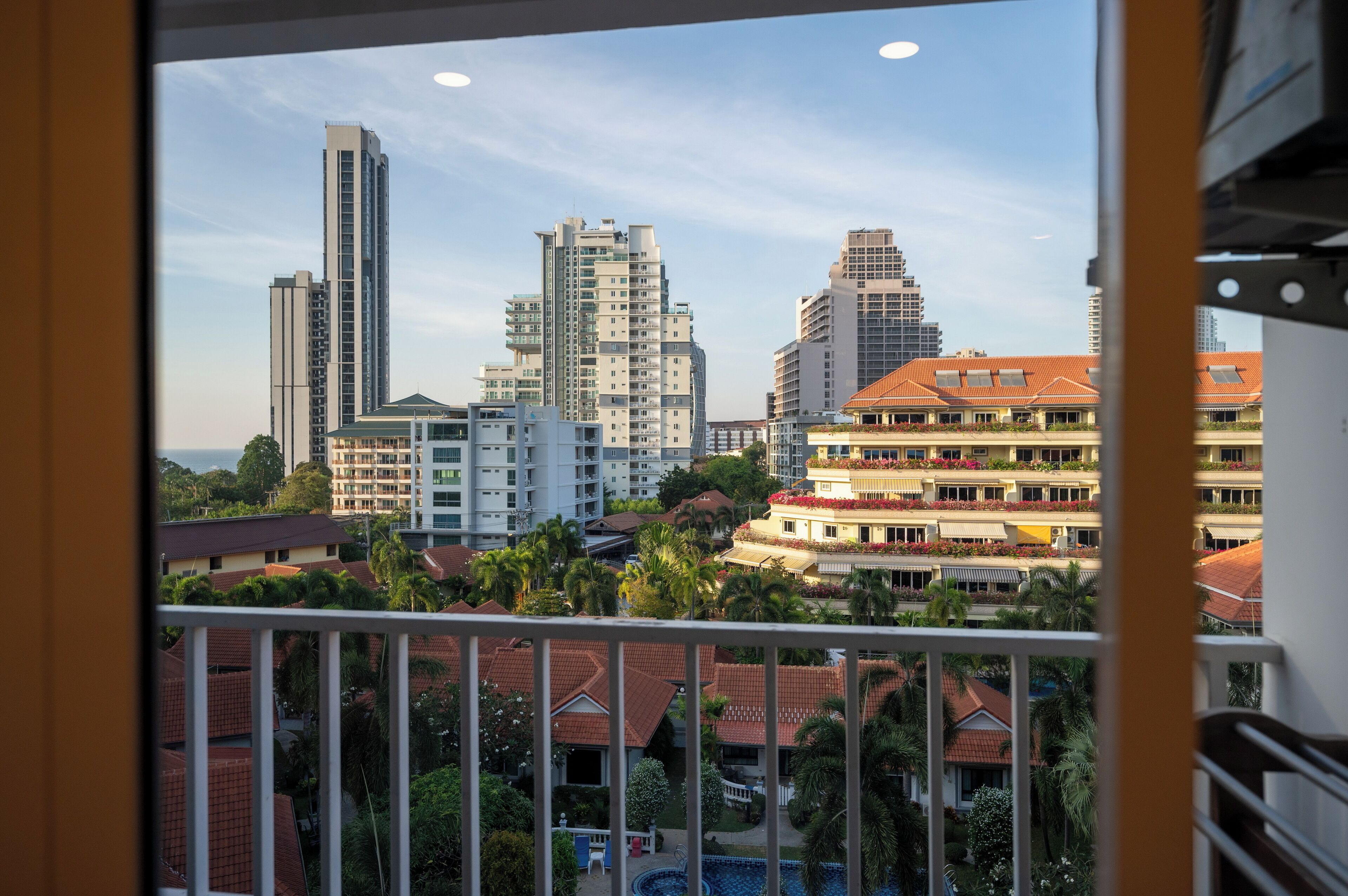 A high-rise hotel with multiple floors, balconies, and a pool area visible in the foreground.