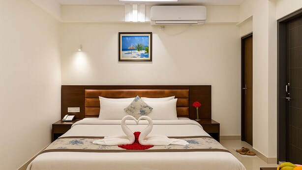 A neatly arranged hotel room with a bed, bedside tables, a wall-mounted air conditioner, and a framed picture above the bed. - Ocean Palace Cox'sBazar (Cox's Bazar)