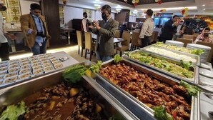 A buffet area with various food options, including meats and salads, in a well-lit indoor setting. - Ocean Palace Cox'sBazar (Cox's Bazar)