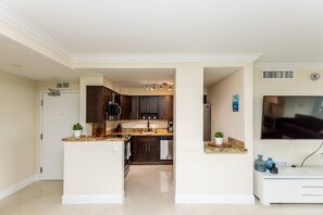 A modern kitchen with dark cabinets, a granite countertop, and a built-in oven.