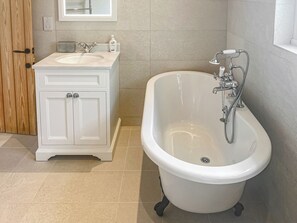 Un baño con tocador blanco, bañera y ducha.