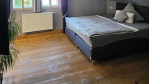 A bedroom with a bed, a radiator, a window with curtains, and a plant. - Hotel zum Löwen Herborn (Herborn)