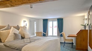 A hotel room with a large bed, a desk, a chair, and a window with curtains. - Hotel zum Löwen Herborn (Herborn)