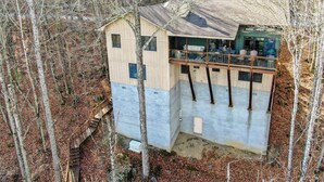 A cabin with a balcony, surrounded by trees. - The Raven (Banner Elk)
