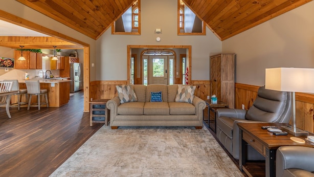 A cozy living room with a wooden ceiling, a sofa, a recliner, and a coffee table. - White Tail Cottage (Banner Elk)